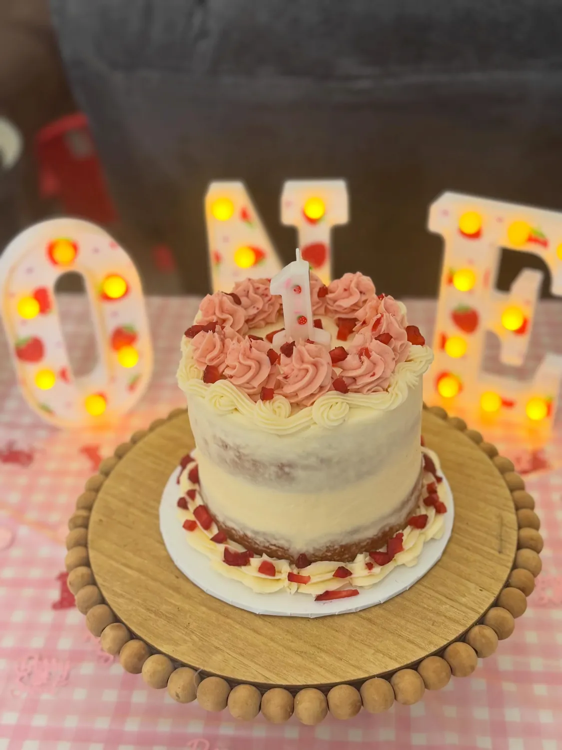 Strawberry smash cake in front of light-up ONE letters