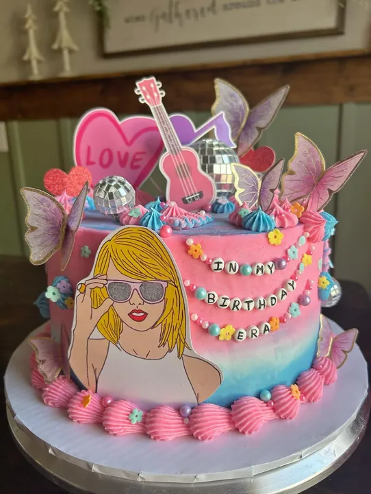 Pop-star birthday cake with hearts, butterflies and a guitar topper
